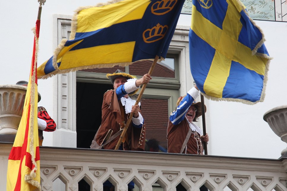 Und vom Rathausbalkon hissen die Schweden ihre Fahne. Glauben Sie nicht? Ist aber so