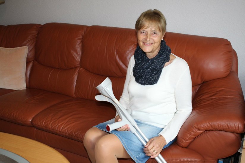 Christiane Schöler mit Krücken auf ihrem Sofa. Nach dem kaputten Kniegelenk im Sommer 2021 zog sie sich kürzlich einen Bänderriss zu.