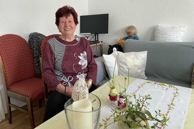 Martina Kunert am Wohnzimmertisch in ihrer neuen Wohnung. Tisch und Stühle sind ebenfalls Spenden.