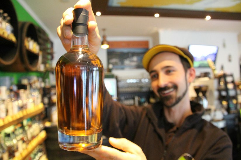 Roy Arnold zeigt den Whisky: Nachgereift in einer schottischen Brennerei, aber in einem Dresdner Weinfass.  Foto: Schramm
