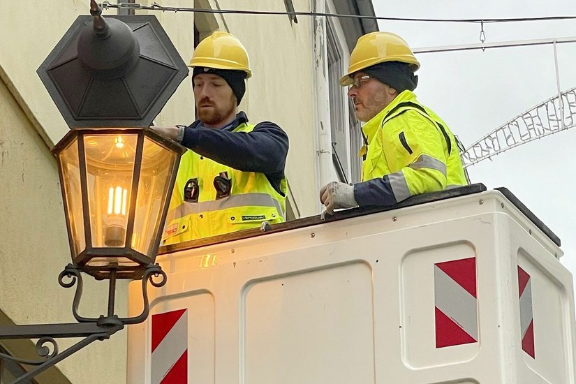 Mitarbeiter der Meißener Stadtwerke setzen die erste neue Leuchte in der Burgstraße ein.  Die Lichtfarben sind sehr ähnlich.