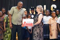 Andrea Kunert, Leiterin der K&amp;S Seniorenresidenz Lübben, übergibt den Spendenscheck über 10.000 Euro an Anthony Mulongo, Leiter des Mudzini Kwetu Centre bei der Graduierungsfeier am 28. Oktober.
