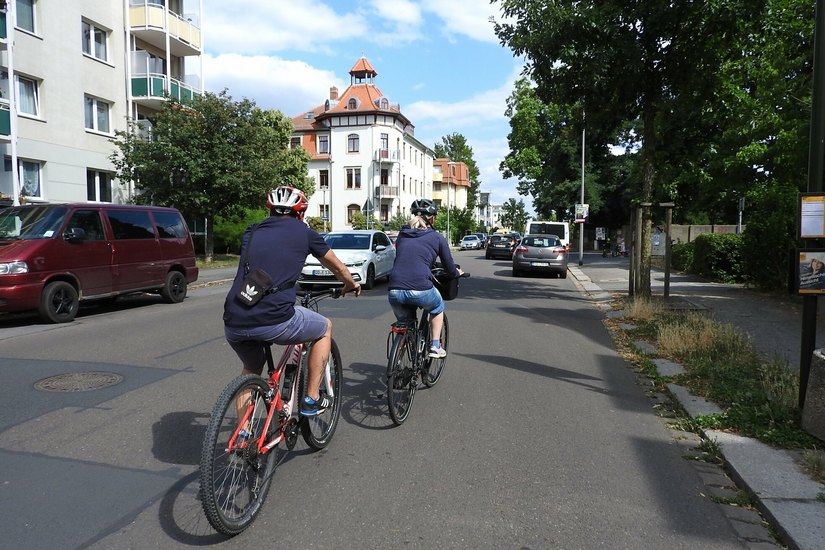 Auf der Kipsdorfer Straße teilen sich Fahrräder, Busse, fahrende und parkende Autos die enge Fahrbahn.  Sie wird  als Teil der »Radroute Ost« zur Fahrrad-Vorrangstraße.