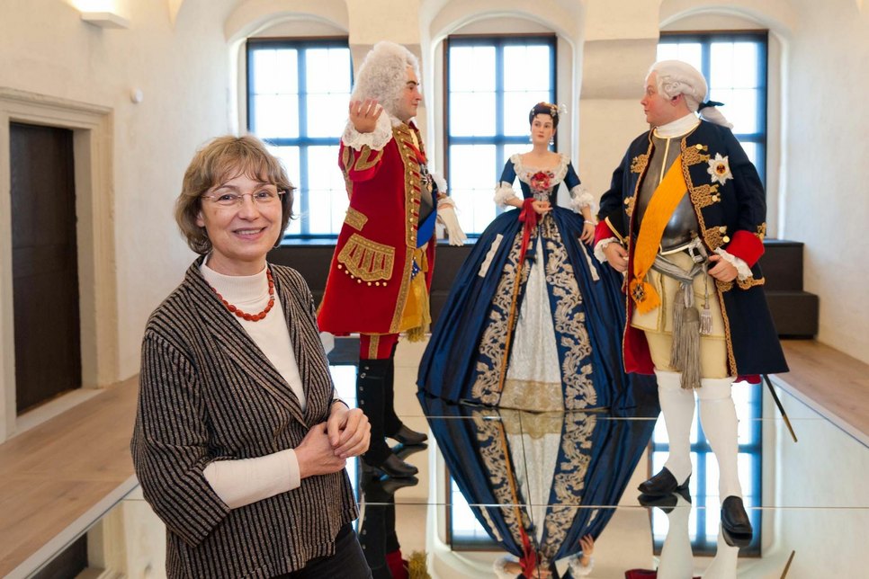 Dr. Angelika Taube  vor lebensgroß nachgebildeten Figuren der Ausstellung.  Foto: PR