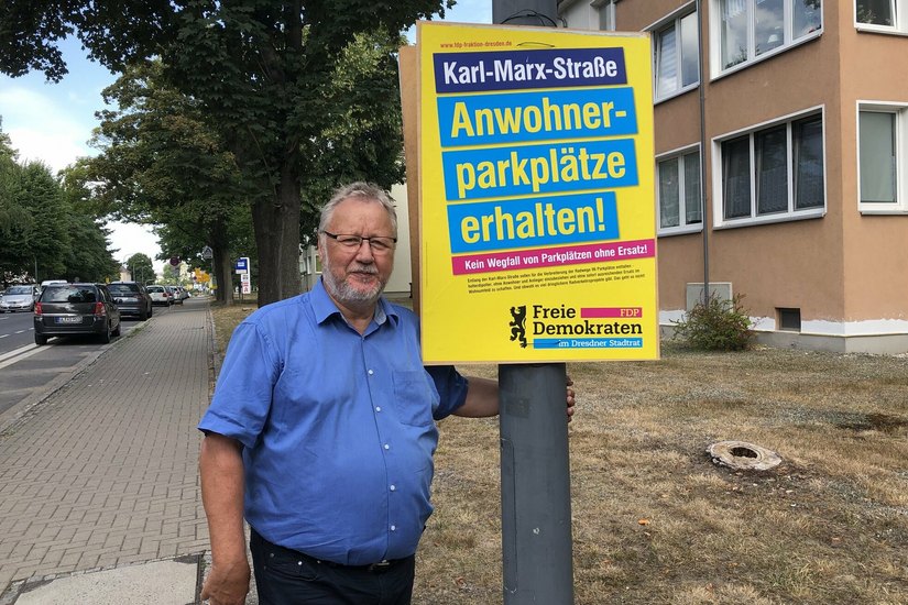 FDP-Stadtrat Franz-Josef Fischer an einem der Plakate an der Karl-Marx-Straße.