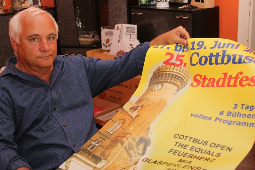 Eberhard Heieck, Chef der Agentur COEX, mit dem offiziellen Plakat zum 25. Cottbuser Stadtfest. Sein Unternehmen ist u.a. auch für das Programnm des Peitzer Fischerfestes (dieses Jahr: 12. bis 15. August) und den Weihnachtsmarkt Cottbus zuständig. Foto: jho