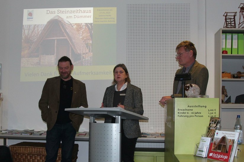 Thorsten Helmerking, Sabine Hacke und Dr. Hans Joachim Behnke (v.l.n.r.) präsentieren das Buch vom Steinzeit-Hausbau im ATZ Welzow.