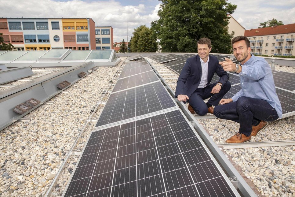 ENSO-Kommunalvertriebsleiter Gunnar Schneider (li.) und Weinböhlas Hochbauamtsleiter Christoph Krzikalla machen sich auf dem Dach des Schulanbaus ein Bild von der neuen Photovoltaikanlage