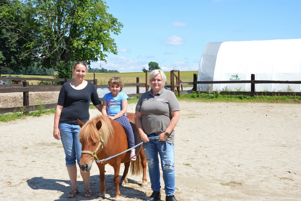 Tessa mit Pony Polly und Mama sowie Reittherapeutin Nicole Wieberneit (r.). Foto: Sonnenstrahl e.V.