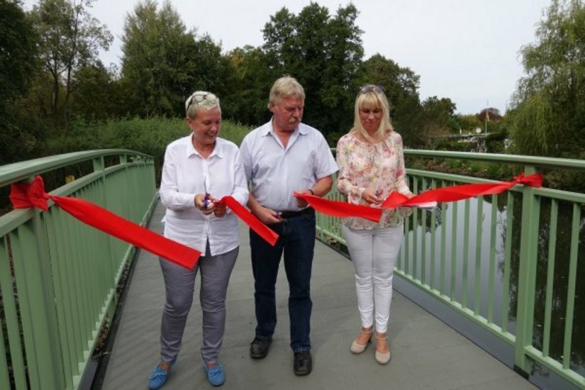 Simone Taubenek, Ullrich Dunkel und Heike Korittke (v.l.) eröffneten mit dem Durchschnitt des roten Bandes die Brücke nun offiziell. Foto: Stadt Forst