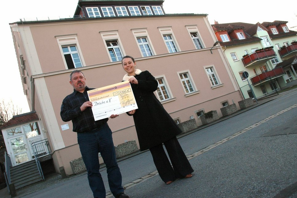 Matthias Nagel und Romy Kopsch bei der Scheckübergabe vorm „Haus der Begegnung“, das der Brücke-Verein in der Dresdener Straße betreibt. Foto: Hache