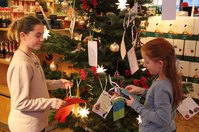 Ayla und Angelie (v.l.) hängen die Wunschzettel an den Weihnachtsbaum.