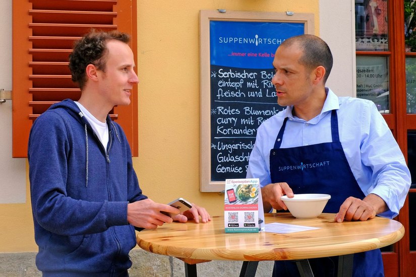 Martin Bruck im Gespräch mit Michael Malz (v.l.), Betreiber der Suppenwirtschaft am Schillerplatz. Foto: PR/SpeiseplanApp