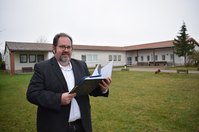 Bürgermeister Hardy Glausch steht am Standort des Gemeindebegegnungszentrum im Ortsteil Quatitz. Hier soll ein Neubau einer Kita entstehen.