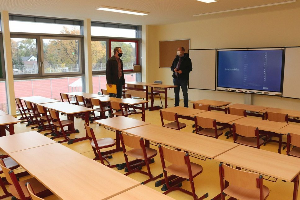 Bürgermeister Lars Kolan und René Pötschick, technischer Sachbearbeiter im Gebäudemanagement, in einem Klassenraum. Foto: Stadtverwaltung