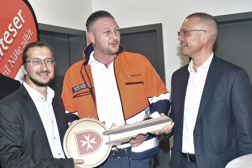Malteser Oliver Kümmich, Leiter der Rettungswachen Großenhain und Thiendorf, und Bürgermeister Dirk Mocker erhalten vom Landrat Ralf Hänsel den symbolischen Schlüssel für die neue Rettungswache in Thiendorf.