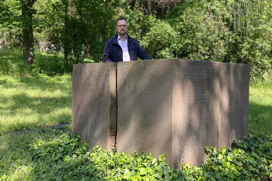 Holger Hase am Block-Grabstein für die Bombenopfer der Luftangriffe. Gepflegt ist das Umfeld nicht.