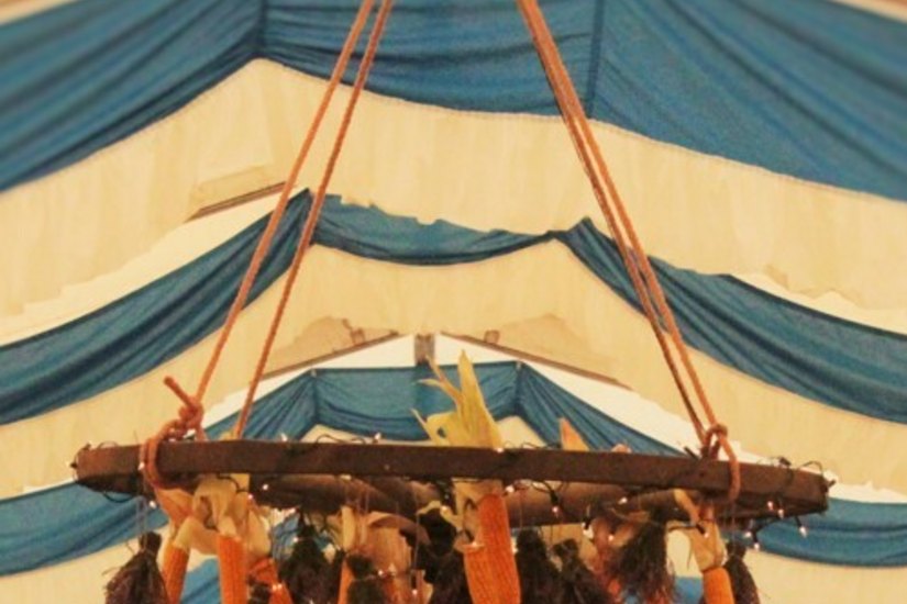 Die selbst geknüpfte Erntekrone schmückt das Zelt.
       Foto: Susanne Gadegast