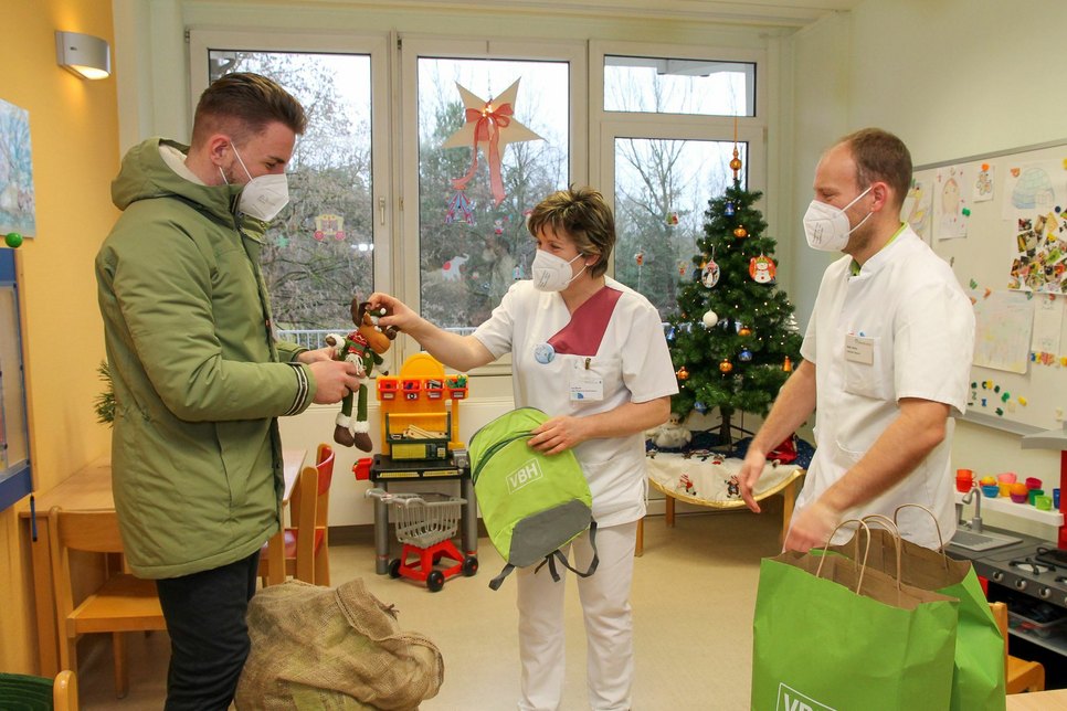 Vertriebsleiter Steven Knobel (li.) übergibt die Weihnachtsgeschenke auf der Kinderstation an Schwester Ina und Oberarzt Maik Heine (re.). Foto: LSK/ Gernot Schweitzer