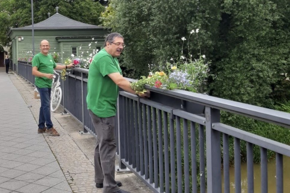 Ralf-Dieter Drews (links) und Jörg Pietsch vom LAGA-Verein montieren nun auch auf der zweiten Seite des Brückengeländers Blumenkästen. Foto: LAGA-Verein