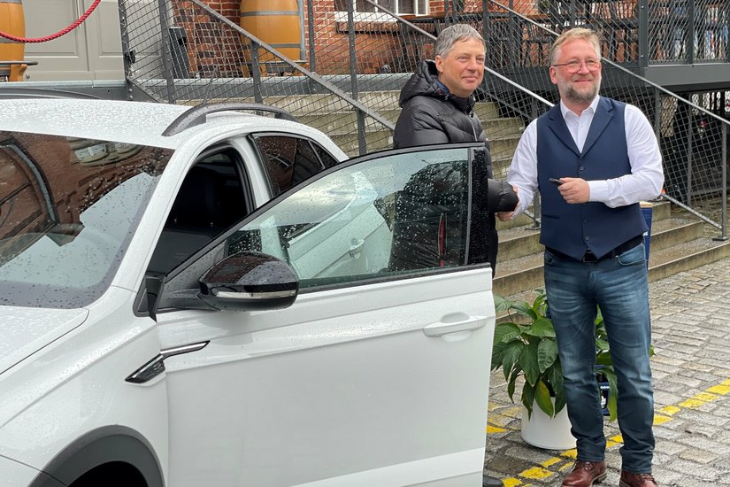 Landskron-Geschäftsführer Uwe Köhler übergibt den Schlüssel für den brandneuen VW Taigo an Frank Fest (links).