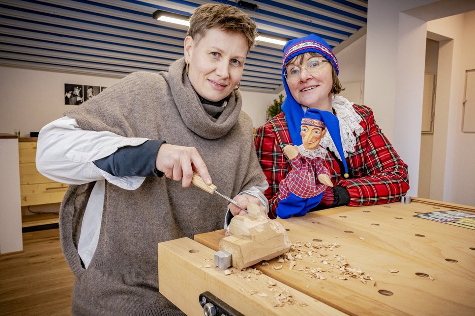 Schnitzerin Elisabeth Trobisch (li.) und Heike Krause vom Traditionsverein (re.) zeigen, wie aus einem Stück Holz ein Hohnsteiner Kasper wird.