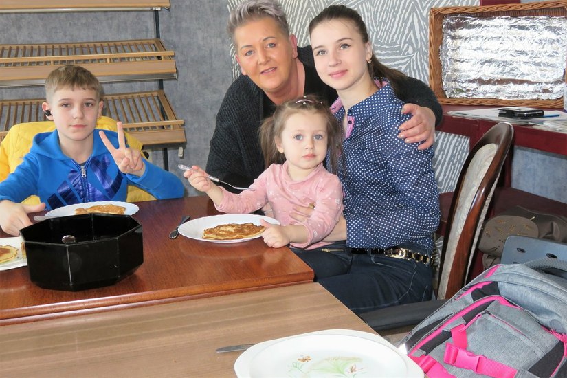 Karin Rauschenbach vom Vorstand der Freitaler Tafel mit einer ukrainischen Familie.