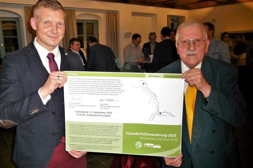 Klaus Fiedler (re.) entrollte mit Bürgermeister Tobias Kummer  das Werbeplakat zur Wanderung.