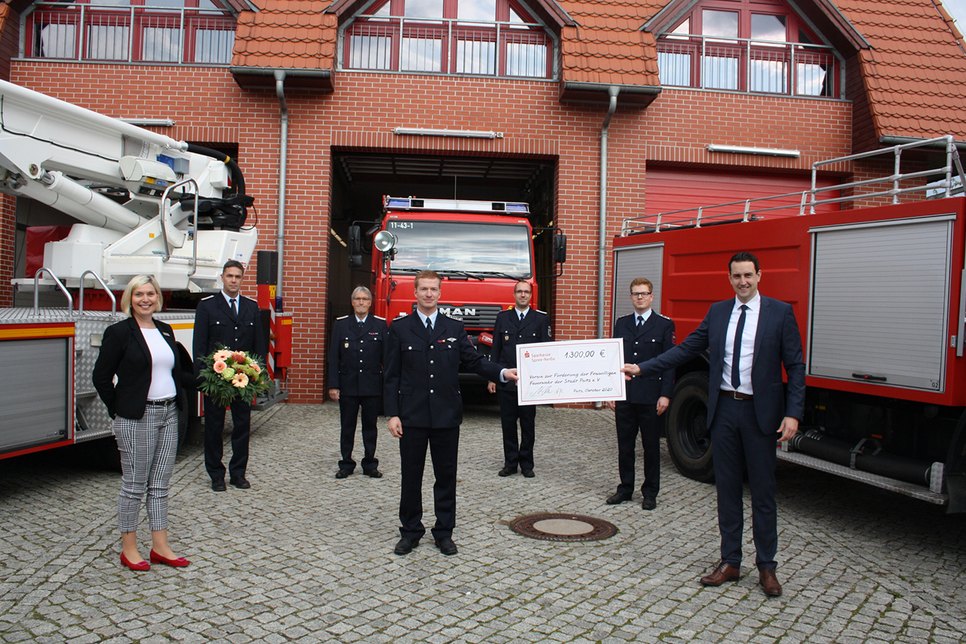 Der Verein zur Förderung der Freiwilligen Feuerwehr der Stadt Peitz e. V. freut sich über den überreichten Scheck. Foto: Sparkasse