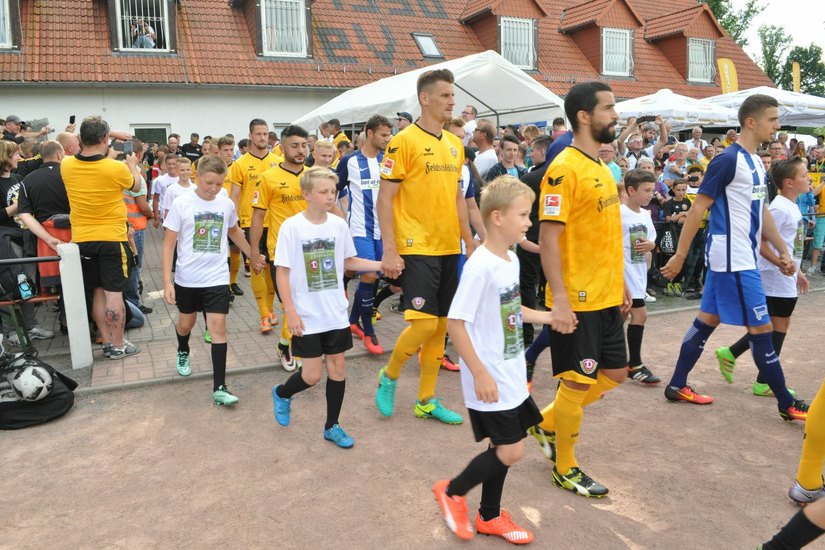 Zum Vorbereitungsspiel gegen den FC Viktoria 1889 Berlin marschieren die Dynamo-Kicker in Großenhain wieder mit ihren kleinen Fans ein. Foto: FischerPRESS