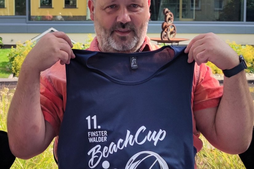 Lars Jäpel zeigt beim Pressegespräch das Shirt zum Beach-Cup 2023.  Foto: Weser