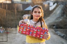 Ein Mädchen in Rumänien freut sich über ihren Schuhkarton.