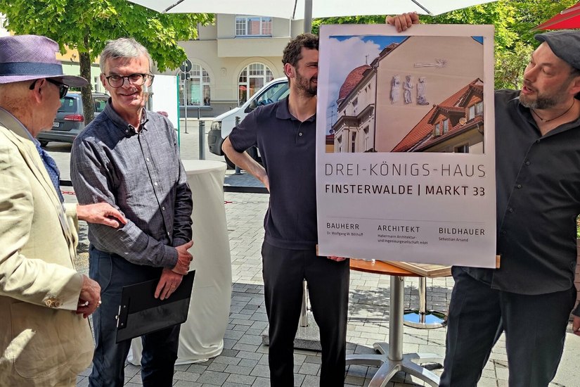 Künstler Sebastian Arsand (re.) zeigt seinen Entwurf der Heiligen Drei Könige Investor Wolfgang Böllhoff (li.) und dem für den Bau verantwortlichen Architekten Jürgen Habermann.