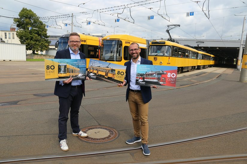 Alexander Hesse (PostModern, re.) und Martin Gawalek, Centerleiter Verkehrsmanagement/Marketing bei der DVB zeigen die neuen Briefmarken.
