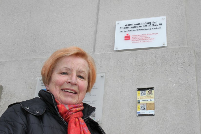 Brigitte Kluttig neben der Fördertafel, die vergangene Woche an der Johanniskirche angebracht wurde. Foto: Keil