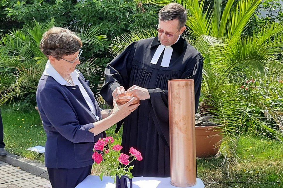 Oberin Schwester Esther Selle und Rektor Stephan Siegmund versiegeln die Kupferhülse für die Grundsteinlegung.