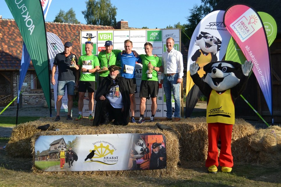 Der Schwarze Müller und Bürgermeister Mirko Pink (r.) gratulieren dem Sieger-Team.