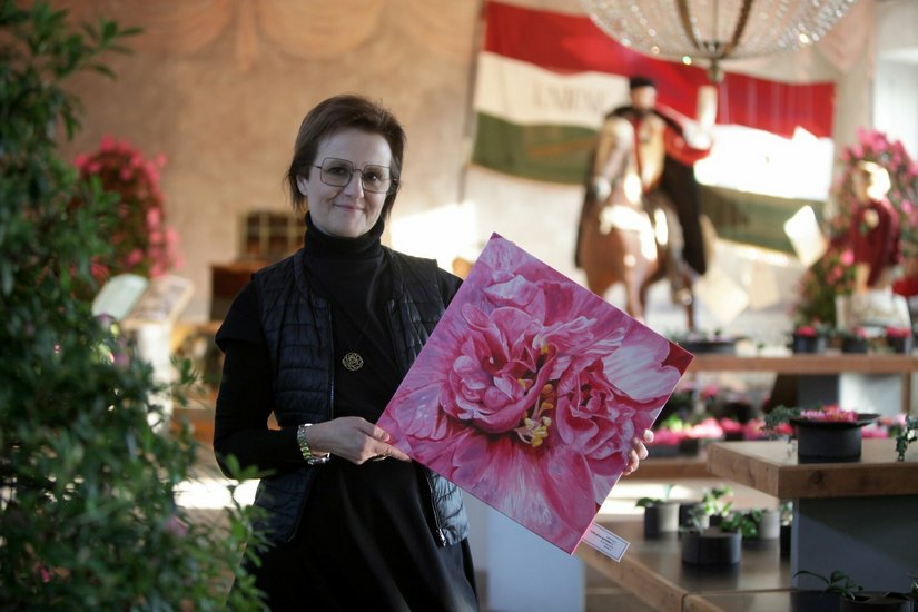 Isabel Pacini mit einem ihrer Werke im Schloss Zuschendorf – dahinter ein Ensemble, das die Kamelie als Symbol des Freiheitskampfes in Italien zeigt.