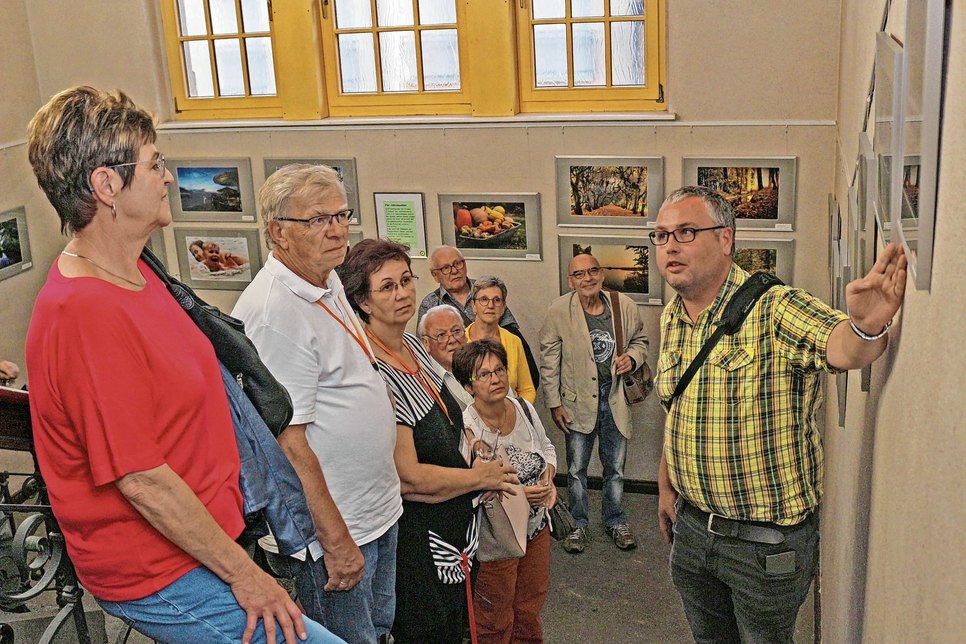 Matthias Nerenz (re.) ist einer der acht Fotografen der AG »FotoGen« des Heimatvereins, die derzeit im Calauer Rathaus ihre Fotografien zeigen. Er erläuterte seine Aufnahmen den neugieren Besuchern der Vernissage. Foto: Stadt Calau