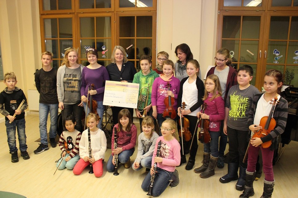 Die jüngsten Musikschüler – Mitte Angelika Reiß mit dem symbolischen Scheck.   Foto: Lions