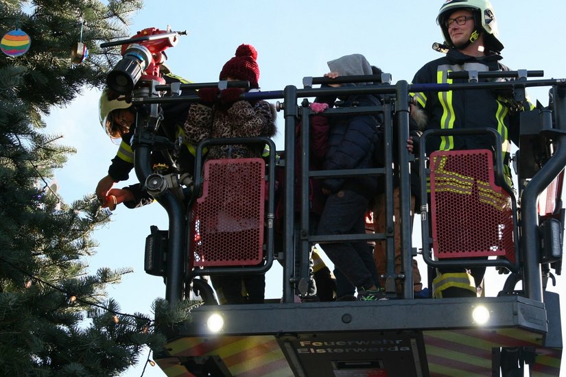 Mit Hilfe der Kameraden der Feuerwehr und ihrer Drehleiter wurde der Weihnachtsbaum der Kinder in Elsterwerda geschmückt.