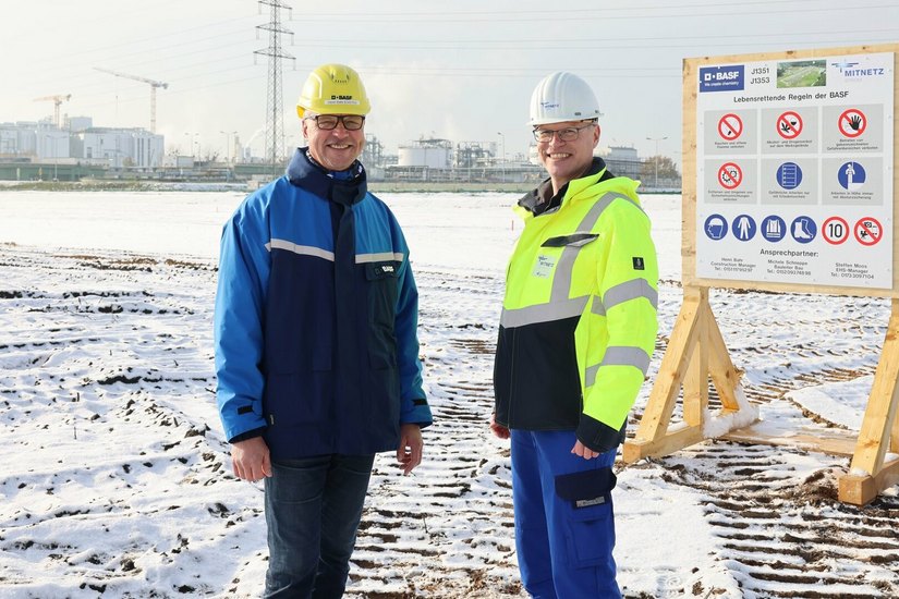 Henri Bahr (l.), Construction Manager seitens der BASF Schwarzheide GmbH, und Uwe Gröger, Baustellenkoordinator seitens MITNETZ STROM, auf dem Blockfeld, wo das zukünftige 110kV-Umspannwerk stehen wird.