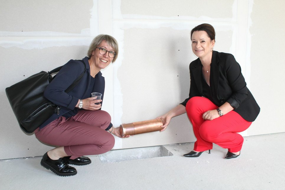 Silke Schlegel (l.) und Christina Lumper vom Vorstand der Diakonie Libera versenkten im Obergeschoss des neuen Quartierhauses eine Zeitkapsel. Foto: sr