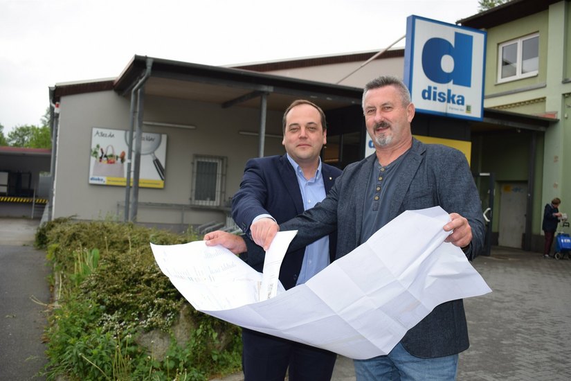 Der Edeka Regionalleiter Jan Hašek (links) und der Planer für den Hochwasserschutz ,Dip.-Ing. Maik Hübschmann, stehen vor dem Diska-Standort, wo kommendes Jahr gebaut werden soll.