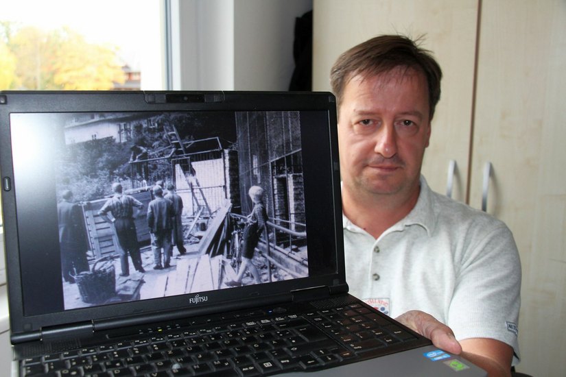 Tierparkleiter Holger Loser zeigt eines der wenigen Fotos aus der Geschichte des Parks. Das Bild stammt aus den 60er Jahren und zeigt einen Gehegebau. Oben links ist teilweise das Kommandantenhaus der Schloss- und Festungsanlage Senftenberg zu erkennen. Foto: sts