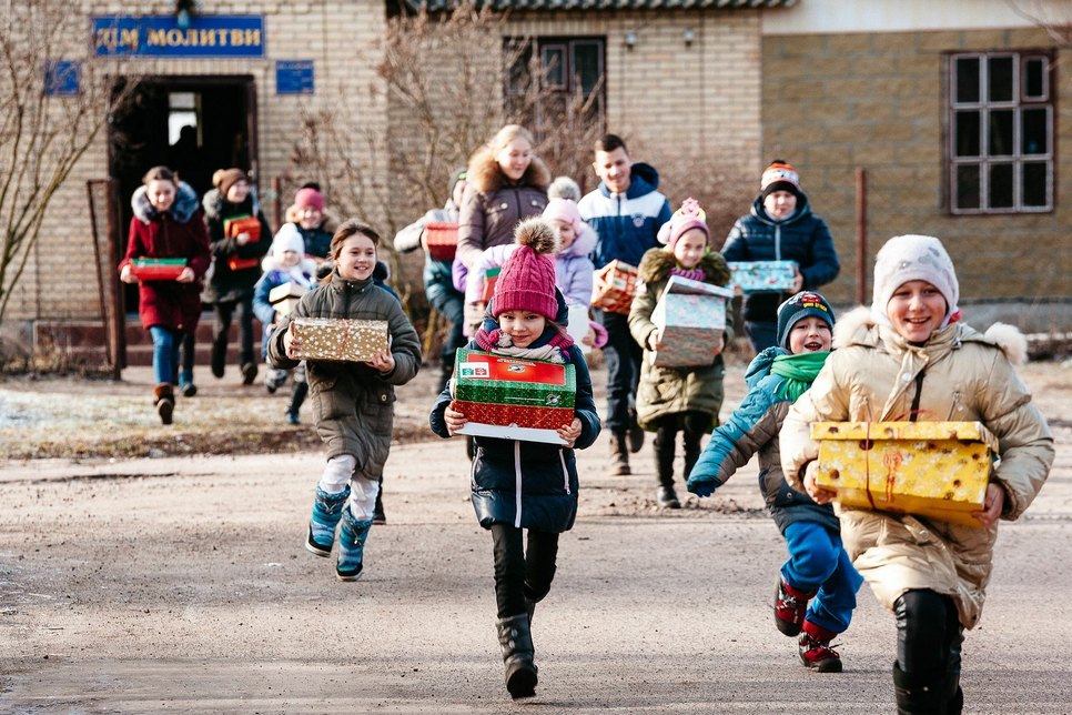 Nach einer Schuhkarton-Verteilung in der Ukraine: Glücklich laufen die Kinder mit ihren Geschenkpäckchen nach Hause. Foto: David Vogt