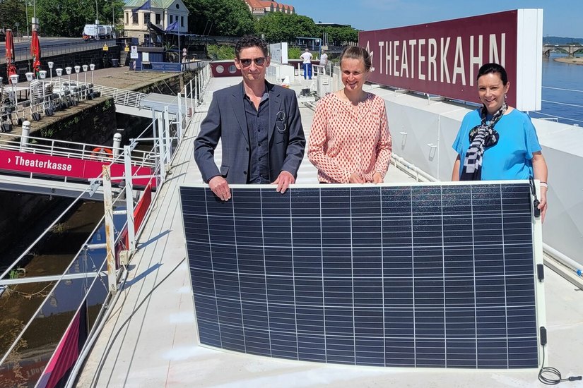 Übergabe eines Solar-Panels durch die SachsenEnergie-Projektverantwortliche Ines Kirner (re.) an Theaterkahn-Intendant Holger Böhme (li.)