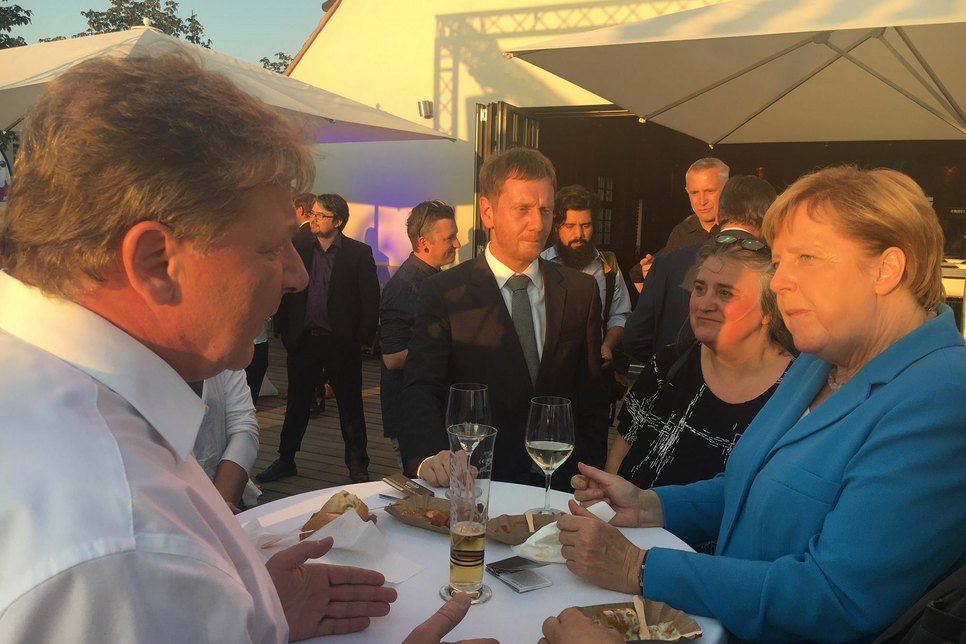 Verlagsleiter Torsten Berge (l.) im Gespräch mit Bundeskanzlerin Angela Merkel (r.) und Ministerpräsident Michael Kretschmer (m.). Foto: Hirche
