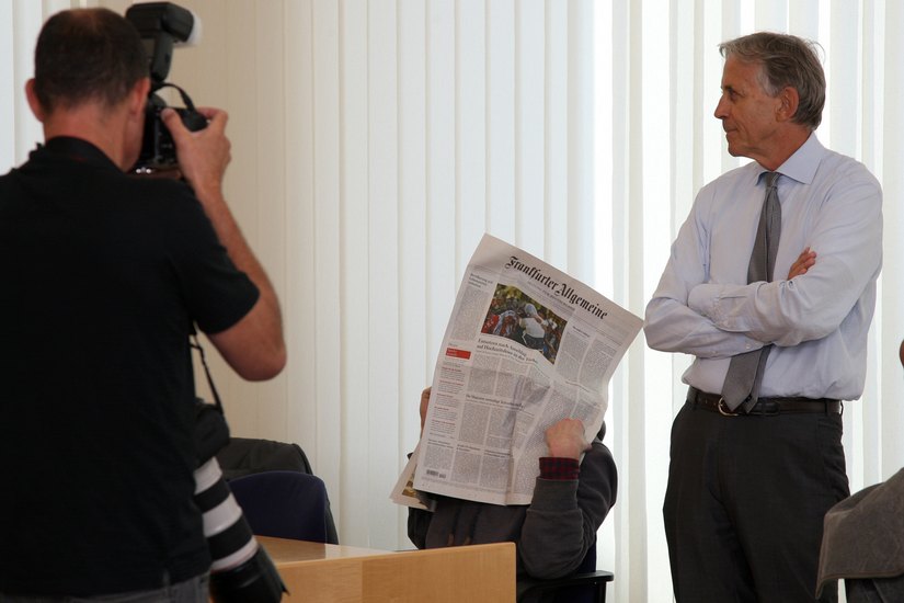 Samuel, versteckt hinter der Zeitung, mit seinem  Anwalt Walter Venedey bei Prozessbeginn.                    Foto. D. Förster