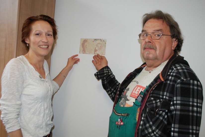 Katja Knoch zeigt mit Günther Schmalfuß, einem Helfer im Museum auf die freigelegten Farbschichten. Foto: Wo